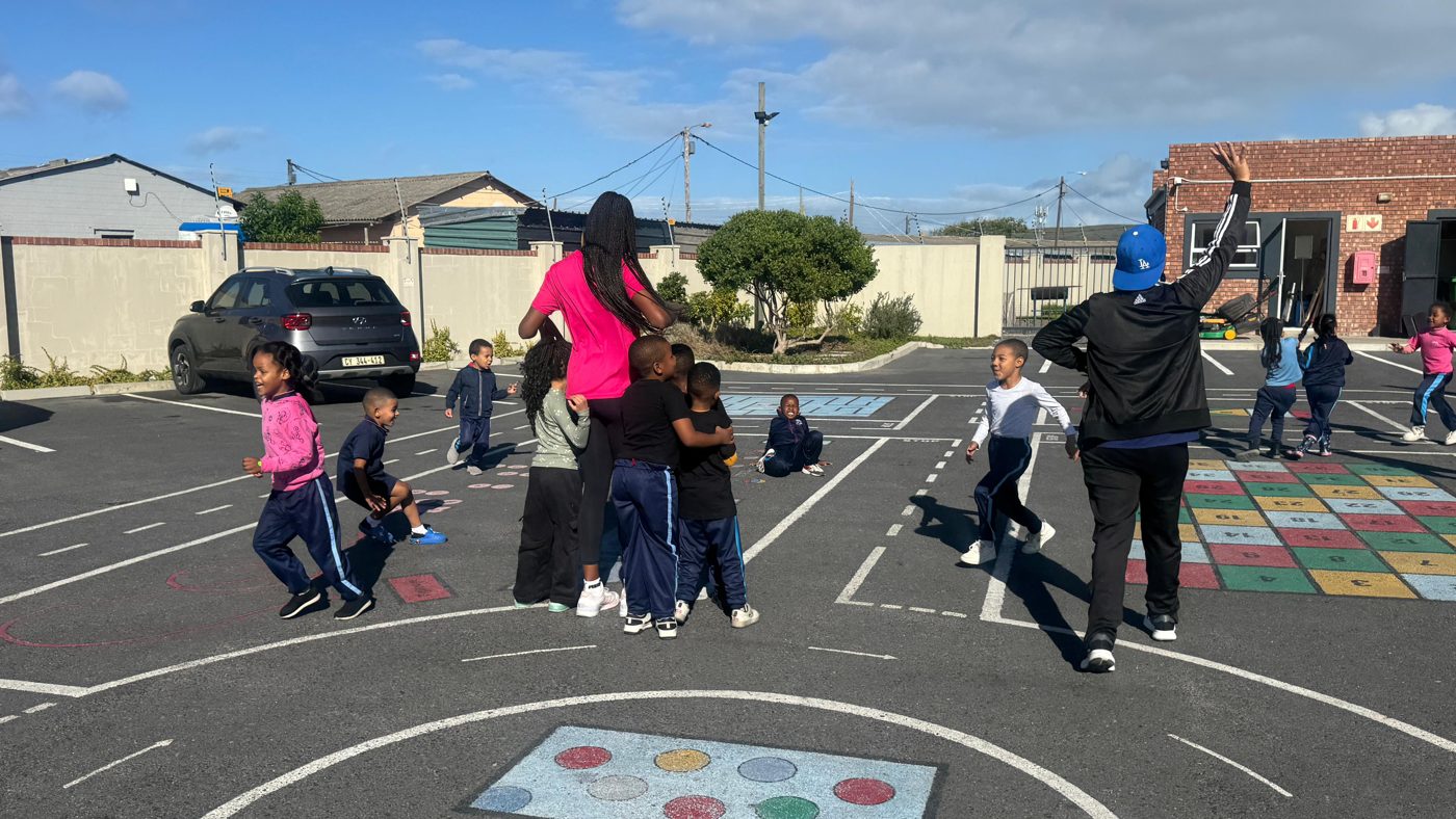 Learners running and playing around the cone stations on the school playground
