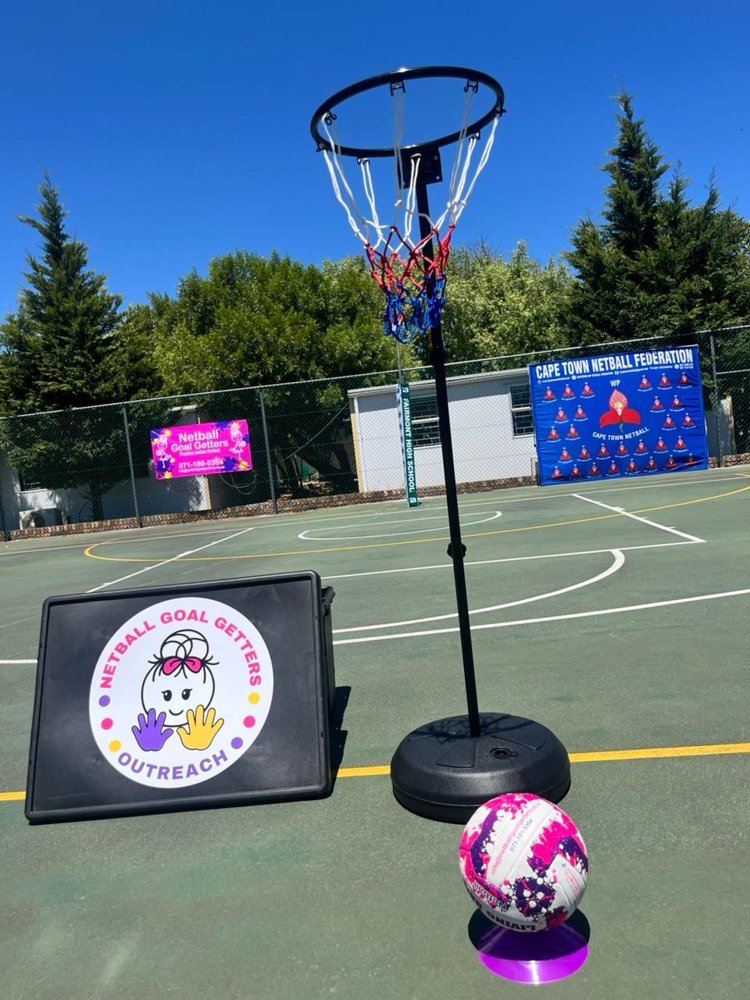 A Netball Goal Getters Outreach tray beside a netball on a court